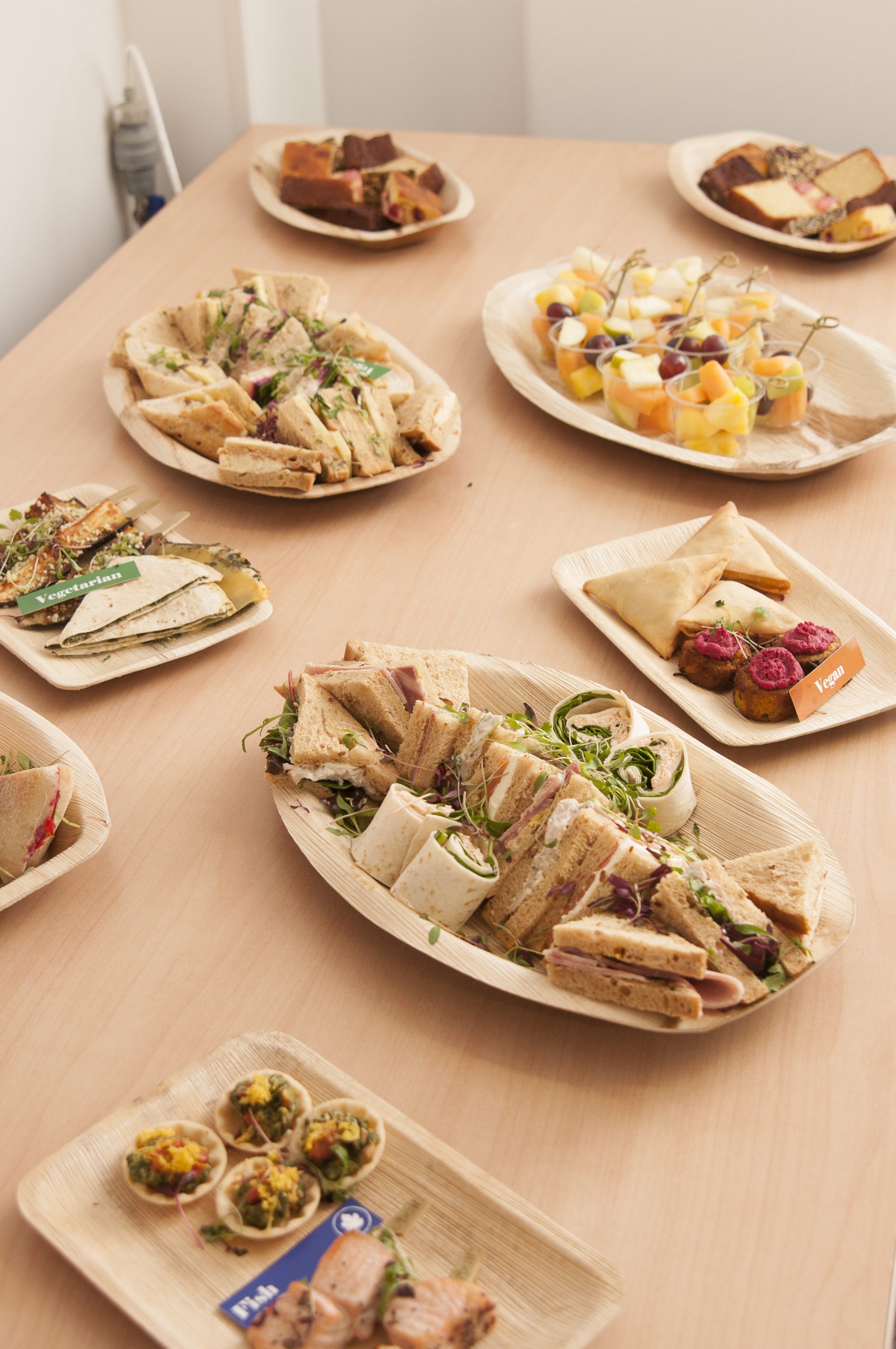 A variety of sandwich and finger buffet platters on a table.